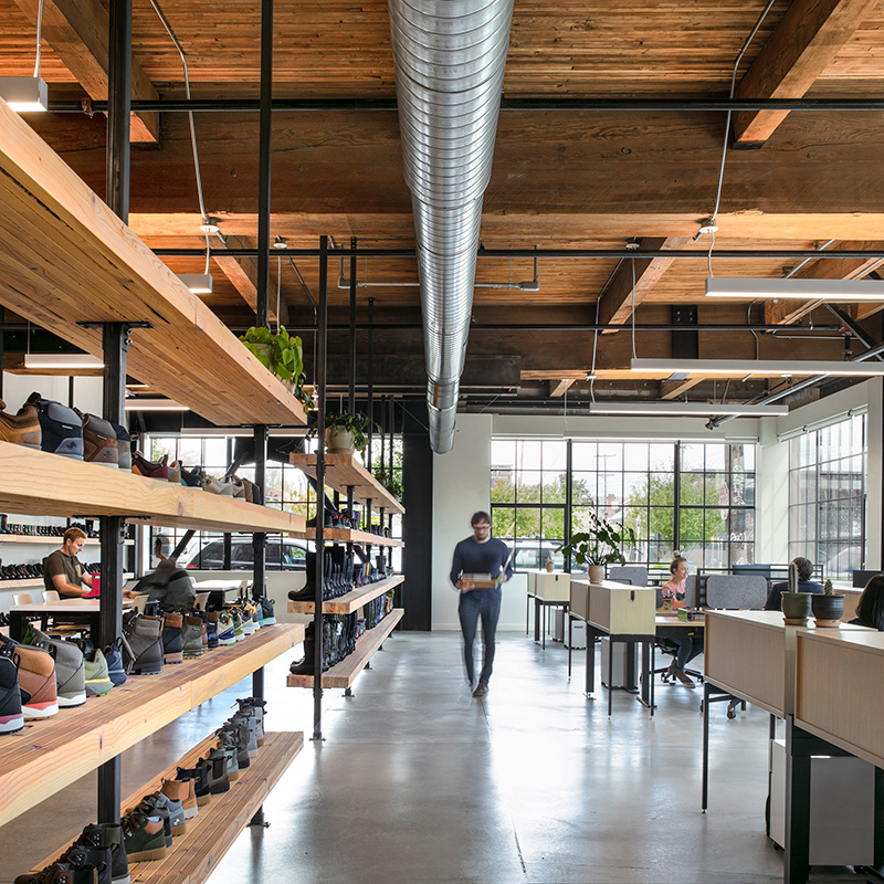 Person walking in an open office space with shoe racks